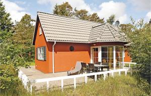 a small orange house with a wooden deck at Tefres in Snogebæk