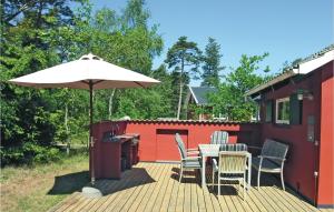 a deck with a table and chairs and an umbrella at Tefres in Snogebæk