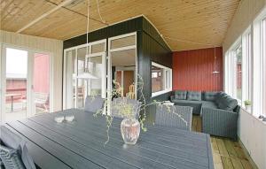 eine Veranda mit einem Holztisch mit einer Vase darauf in der Unterkunft Lrkereden, in Allinge