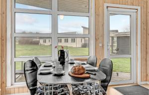 comedor con mesa, sillas y ventanas en 2 Bedroom Amazing Home In Roslev en Sallingsund