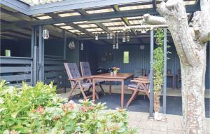 a wooden table and chairs on a patio at Holiday Home Farsø 49 in Hvalpsund