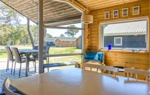 a dining room with a table and chairs and a large window at 2 Bedroom Amazing Home In Nex in Neksø