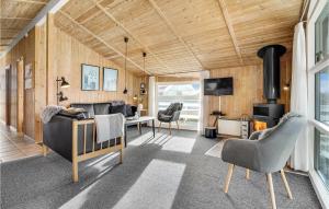 BolilmarkにあるBeautiful Home In Rm With 3 Bedrooms, Sauna And Wifiのリビングルーム(ウッドパネル、ソファ、椅子付)