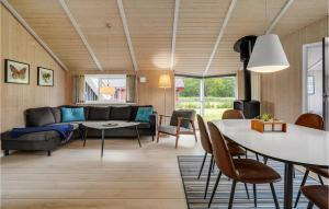 SønderbyにあるAmazing Home In Juelsminde With 3 Bedrooms, Sauna And Wifiのリビングルーム(ソファ、テーブル付)