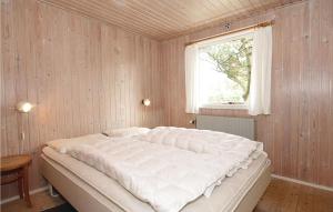 BjerregårdにあるAmazing Home In Hvide Sande With Wifiの窓付きの客室の大型ベッド1台分です。