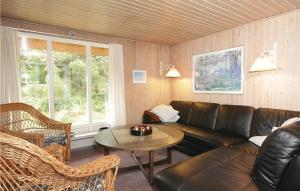 ein Wohnzimmer mit einer Ledercouch und einem Tisch in der Unterkunft Holiday Home Hvide Sande 1146 in Bjerregård