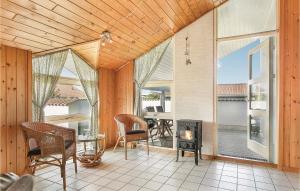 a screened in porch with a fireplace and chairs at Stunning Home In Thisted With Sauna in Klitmøller