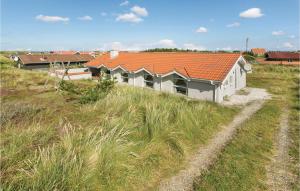 a house with an orange roof on top of a field at Stunning Home In Thisted With Sauna in Klitmøller