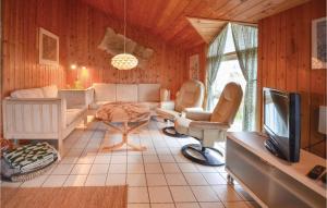 a living room with a couch and a tv at Stunning Home In Thisted With Sauna in Klitmøller