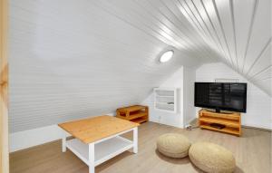 ロモ・キルケビーにあるStunning Home In Rømø With Kitchenのテレビとテーブルのあるリビングルーム