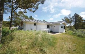 a white house with a table in a field at Holiday Home Sandtornvej Thisted V in Sønder Vorupør