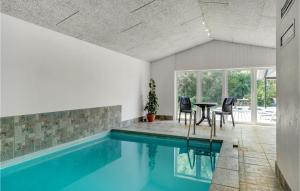 Bøtø ByにあるNice Home In Vggerlse With 5 Bedrooms, Wifi And Private Swimming Poolの家の中のスイミングプール(テーブル、椅子付)