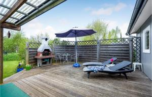 a patio with an umbrella and chairs and a table at 3 Bedroom Lovely Home In Gedser in Gedser +12 photos