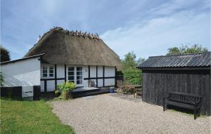 a thatch roofed cottage with a bench and a table at Holiday Home Ølstedvej in Brobyværk