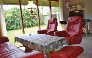 ein Wohnzimmer mit roten Stühlen und einem Tisch in der Unterkunft Holiday Home Støvlen in Hemmet