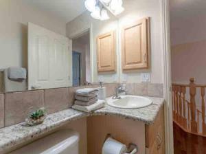 łazienka z umywalką i lustrem w obiekcie 2500 sq house in Springbank Hill BL 261818 w mieście Calgary +74 zdjęcia