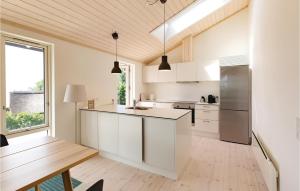 kuchnia z białymi szafkami i drewnianą podłogą w obiekcie Three-Bedroom Holiday Home In Kalundborg w mieście Kalundborg