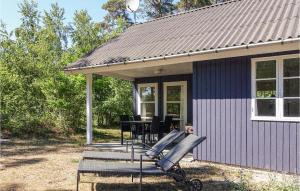 eine Veranda eines Hauses mit einem Tisch und Stühlen in der Unterkunft Stunning Home In Aakirkeby With Wifi in Vester Sømarken + 9 Fotos