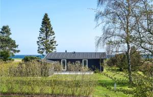 a house with a black roof in a field at Cozy Home In Humble With Sauna in Humble