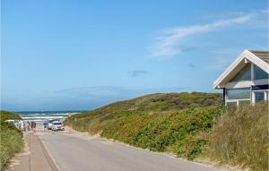 a road next to a beach with a house and the ocean at Pynten in Grønhøj +21 photos