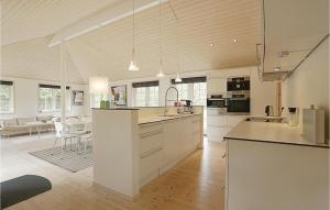 Vester Sømarken的住宿－Cozy Home In Aakirkeby With Wifi，一间大厨房,配有白色的橱柜和一间餐厅