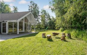 um quintal com um pavilhão com um grelhador e árvores em Nice Home In Vggerlse With 5 Bedrooms, Sauna And Wifi em Bøtø By