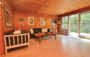 een woonkamer met houten wanden en een houten tafel bij Beautiful Home In Fan With Wifi in Fanø