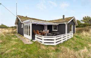 a black cottage with a porch and a table and chairs at Cozy Home In Rm With Wifi in Bolilmark