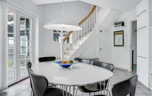 ボーゲンセにあるAmazing Apartment In Bogense With 3 Bedrooms, Sauna And Wifiの白いダイニングルーム(テーブル、椅子付)