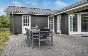 a table and chairs on a brick patio at Holiday Home Lyngvejen Xi in Rømø Kirkeby