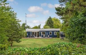 a blue tiny house in the middle of a yard at Beautiful Home In Rnne With Wifi in Arnager