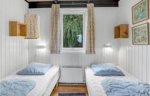 a bedroom with two beds and a window at Beautiful Home In Rnne With Wifi in Arnager