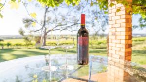 a bottle of wine sitting on a table with two wine glasses at Blickinstal Holiday Retreat in Bethany