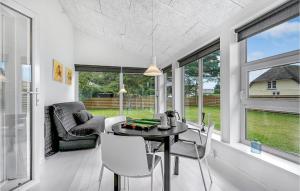 a dining room with a table and chairs and windows at Holiday Home Fjordvej Børkop Ix in Egeskov +20 photos