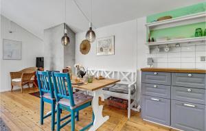 a kitchen with a wooden table and blue chairs at Holiday Home Sølvpoppelvej Væggerløse X in Marielyst