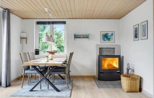 ein Esszimmer mit einem Tisch und einem Kamin in der Unterkunft 3 Bedroom Cozy Home In Glesborg in Fjellerup Strand