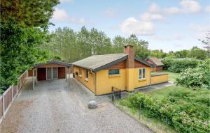 ein gelbes Haus in einem Hof mit Auffahrt in der Unterkunft 3 Bedroom Cozy Home In Glesborg in Fjellerup Strand
