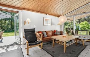 een woonkamer met een bank en een tafel bij Nice Home In Aakirkeby With Wifi in Vester Sømarken