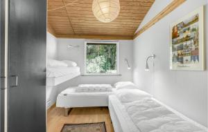 1 dormitorio con 2 camas y ventana en Nice Home In Aakirkeby With Wifi, en Vester Sømarken
