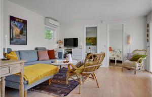 uma sala de estar com um sofá azul e cadeiras em 2 Bedroom Beautiful Home In Grsted em Græsted
