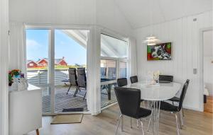 a dining room with a white table and chairs at Strandhus in Bolilmark