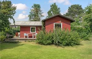 uma casa vermelha com uma mesa e cadeiras em frente em Awesome Home In Fllenslev With Kitchen em Eskebjerg