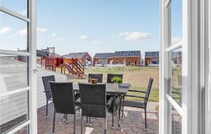a patio with a table and chairs and a playground at Lejlighed 64 in Rømø Kirkeby