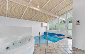 a bathroom with a tub and a swimming pool at Awesome Home In Juelsminde With 4 Bedrooms, Sauna And Wifi in Sønderby