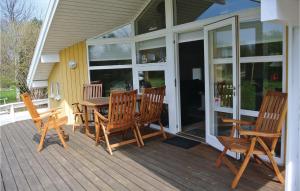 a porch with a wooden table and chairs on it at Holiday Home Kamillevej Tranekær X in Skattebølle