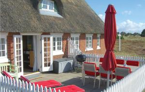 a house with a patio with chairs and an umbrella at Holiday Home Fanø 60 in Sønderho