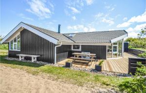 a black house with a picnic table on a deck at 3 Bedroom Stunning Home In Rm in Bolilmark