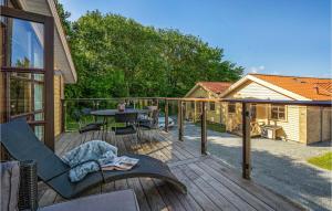 une terrasse en bois avec une table et des chaises. dans l'établissement 3 Bedroom Nice Home In Egernsund, à Egernsund