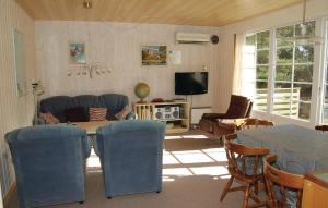 - un salon avec un canapé, une table et des chaises dans l'établissement Amazing Home In Rm With Kitchen, à Bolilmark