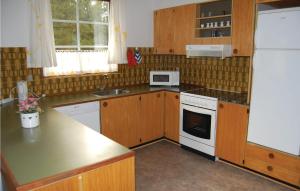una cucina con mobili in legno e un frigorifero bianco di Holiday Home Småfolksvej Rømø Vi a Bolilmark